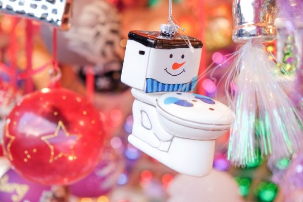 A toilet christmas ornament hanging from a tree