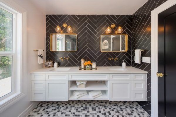 a modern bathroom with black tiled walls and gold plated mirrors