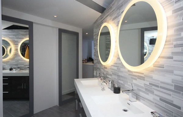 Two round backlit mirrors on the bathroom wall